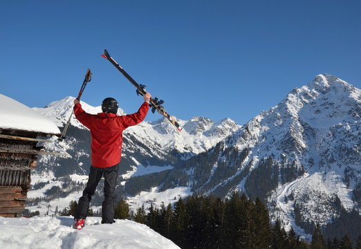 Skifahrer jubelt vor alpiner Kulisse