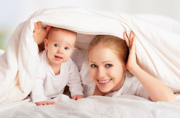 happy family. Mother and baby playing under  blanket