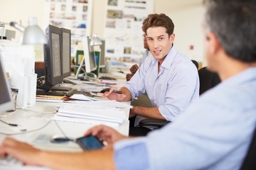 Fototapeta premium Man Working At Desk In Busy Creative Office
