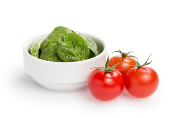 fresh spinach leaves in bowl and tomatoes