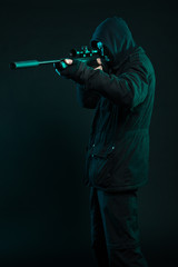 Sniper with beard in black holding gun. Studio shot.
