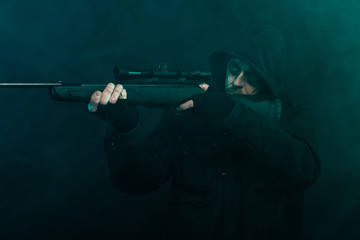 Obraz na płótnie Canvas Snajper z brodą w czarnym posiadania broni. Studio strzał.