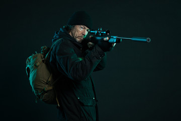 Fototapeta na wymiar Snajper z brodą w czarnym posiadania broni. Studio strzał.