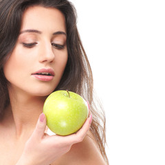 Portrait of a young naked brunette holding a fresh green apple