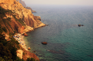 Sea with rocky beach at sunset