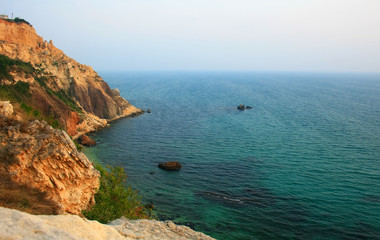 Sea with rocky beach at sunset