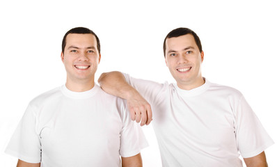 Two attractive positive smiling young men twins isolated