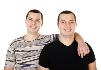 Two attractive positive smiling young men twins isolated