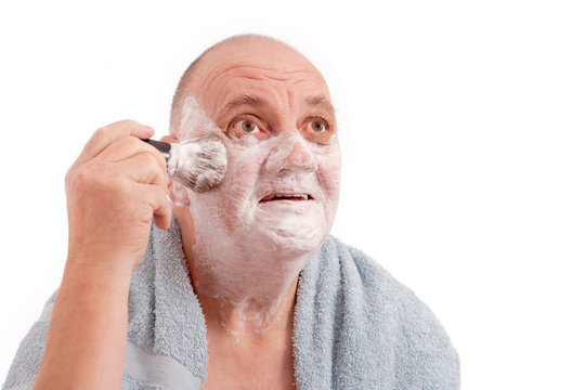 homme qui se savonne la barbe au blaireau