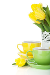Yellow tulips and two tea cups