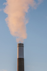 smoking chimnney stack in blue sky