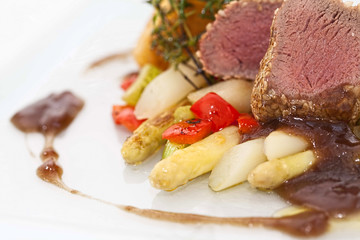 Roasted saddle of lamb on asparagus ragout and herbs