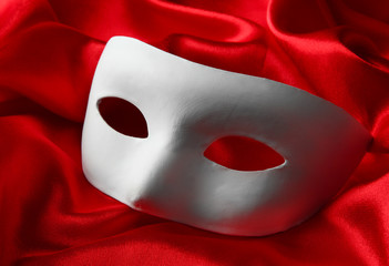 White mask, on red silk fabric