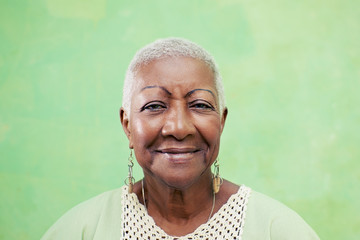 Portrait of senior black woman smiling at camera on green backgr - obrazy, fototapety, plakaty