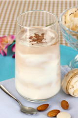 Glass of chocolate-cream cocktail on beige tablecloth close-up