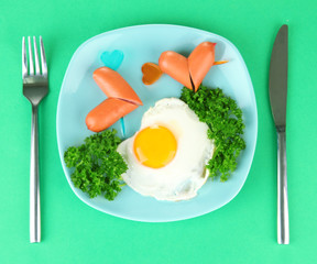 Sausages in form of hearts, scrambled eggs and parsley,