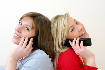 Dos mujeres conversando por teléfono celular.
