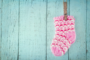 Pink baby socks on a blue wooden background