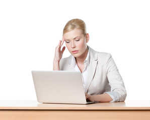 Tired young businesswoman sitting at a table with laptop