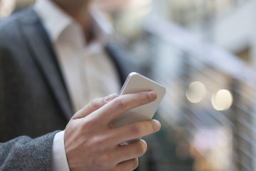 Businessman with smartphone in business building