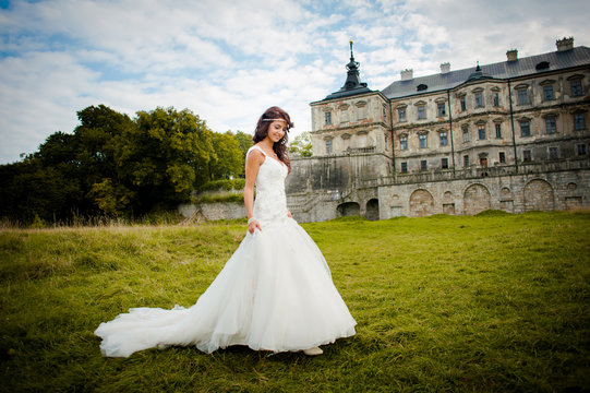 Beautiful bride walks next to castle