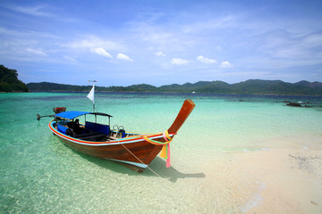 Long tail boat on white sand beach and crystal sea