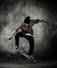 Young man in hat and shirt performing stunt on skateboard