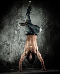 Young b-boy man with naked torso doing brake dancing movements