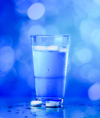 Glass of water on blue background. water with ice in glass