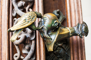 Decorative antique, metal door handles with bird pattern.