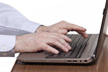 Männliche Hände tippen auf einer Laptop-Tastatur
