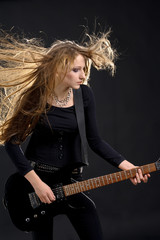 Fashion girl with guitar playing hard-rock