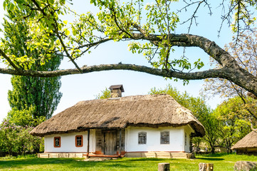 A typical antique Ukrainian country house with a thatch roof, in the countryside near Kiev	