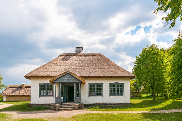 A typical antique Ukrainian country house with a thatch roof, in the countryside near Kiev	