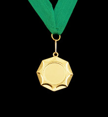 Gold medal with green ribbon isolated on black