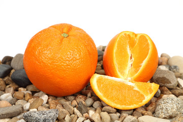 Pomarańcza w całości i pokrojona na kamieniach. - obrazy, fototapety, plakaty