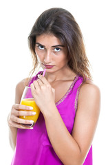 Beautiful seductive young woman drinking orange juice.