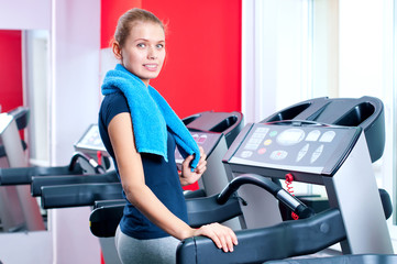 Young woman at the gym run on on a machine