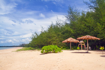 Tropical beach scenery with parasol and deck chairs in Thailand