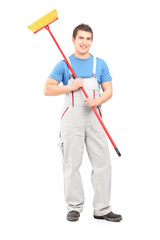 Full length portrait of a smiling cleaner in a uniform with a br