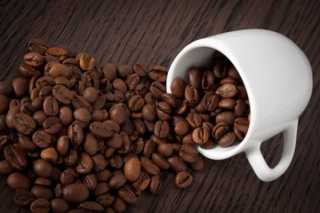 Coffee cup full of roasted coffee beans.