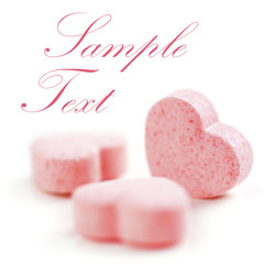 Obraz premium Sweet hearts shaped pink Sugar Pills. Soft Focus. Sample Text.