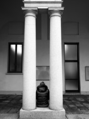 Girl sitting between two columns