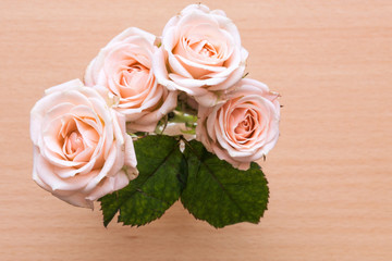 pink roses in a vase on a wooden desk