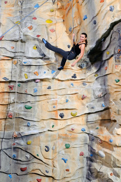 woman on rock wall in sport center