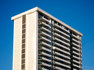 An 80s apartment building on the blue-sky day.