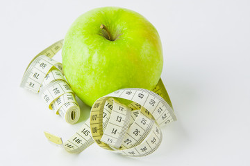 green apple and centimetre on a white background