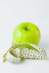 green apple and centimetre on a white background