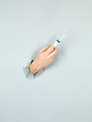 male hand holding syringe