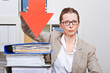 Ernste Frau im Büro zeigt mit Pfeil auf Akte